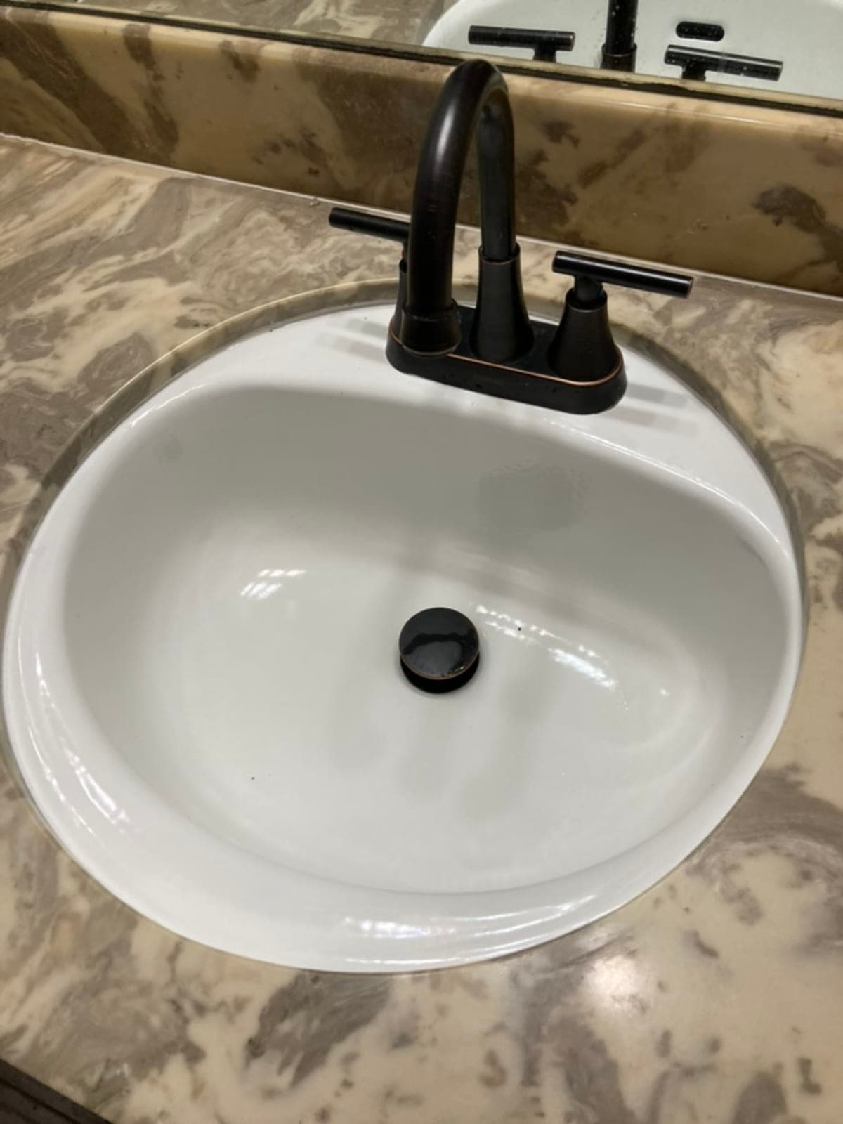 Oil-rubbed bronze centerset faucet on marble countertop
