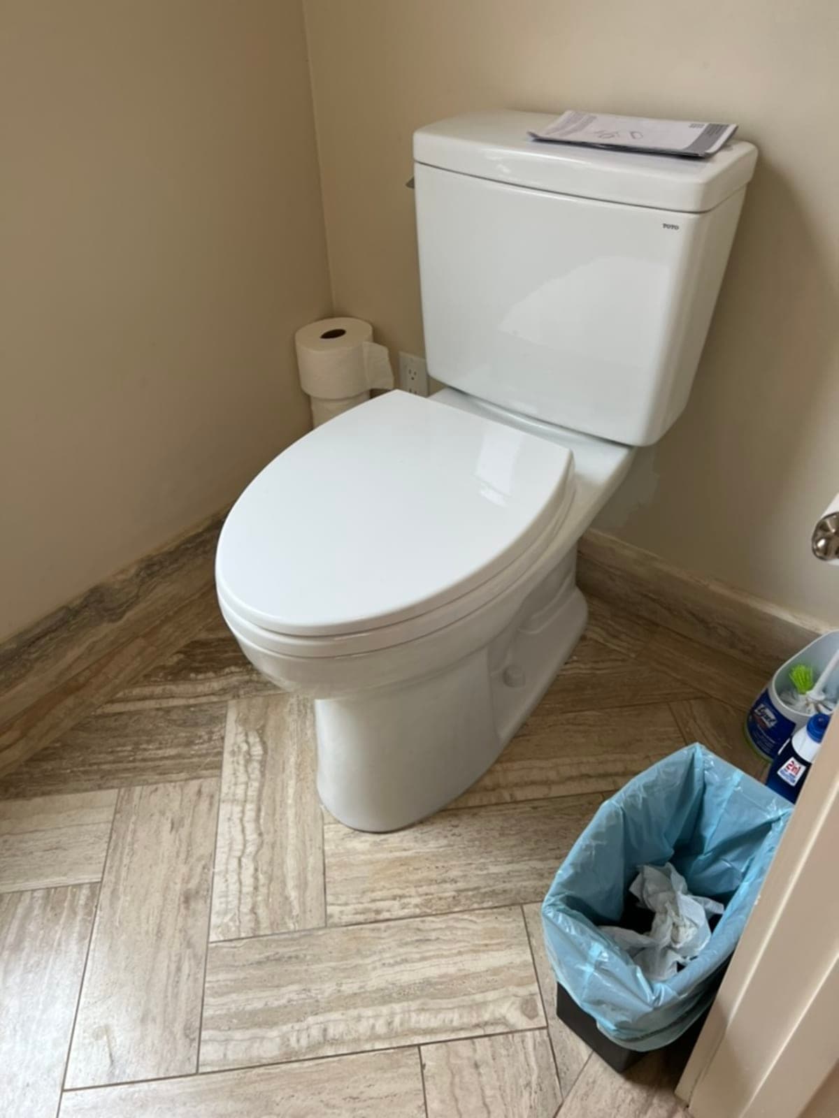 TOTO toilet on herringbone tile floor, clean finished installation