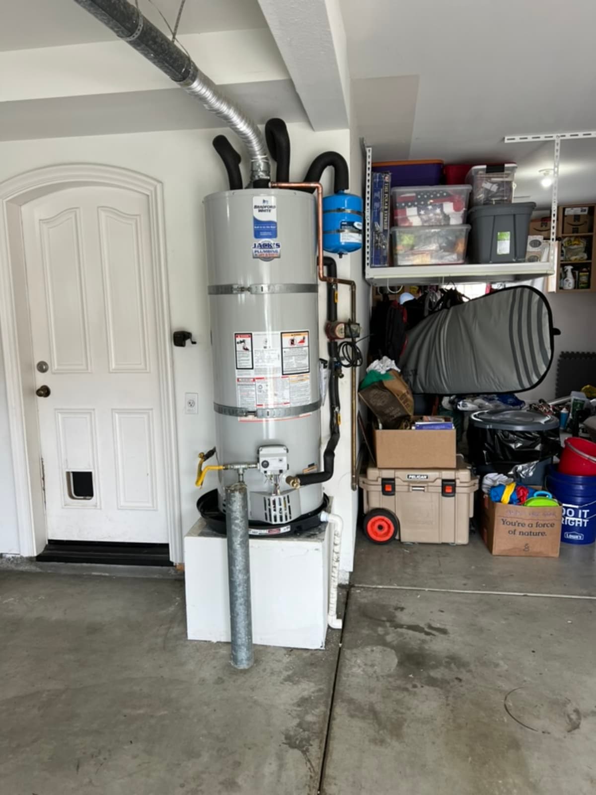 Full-size tank water heater in garage with vent ducting and gas connection