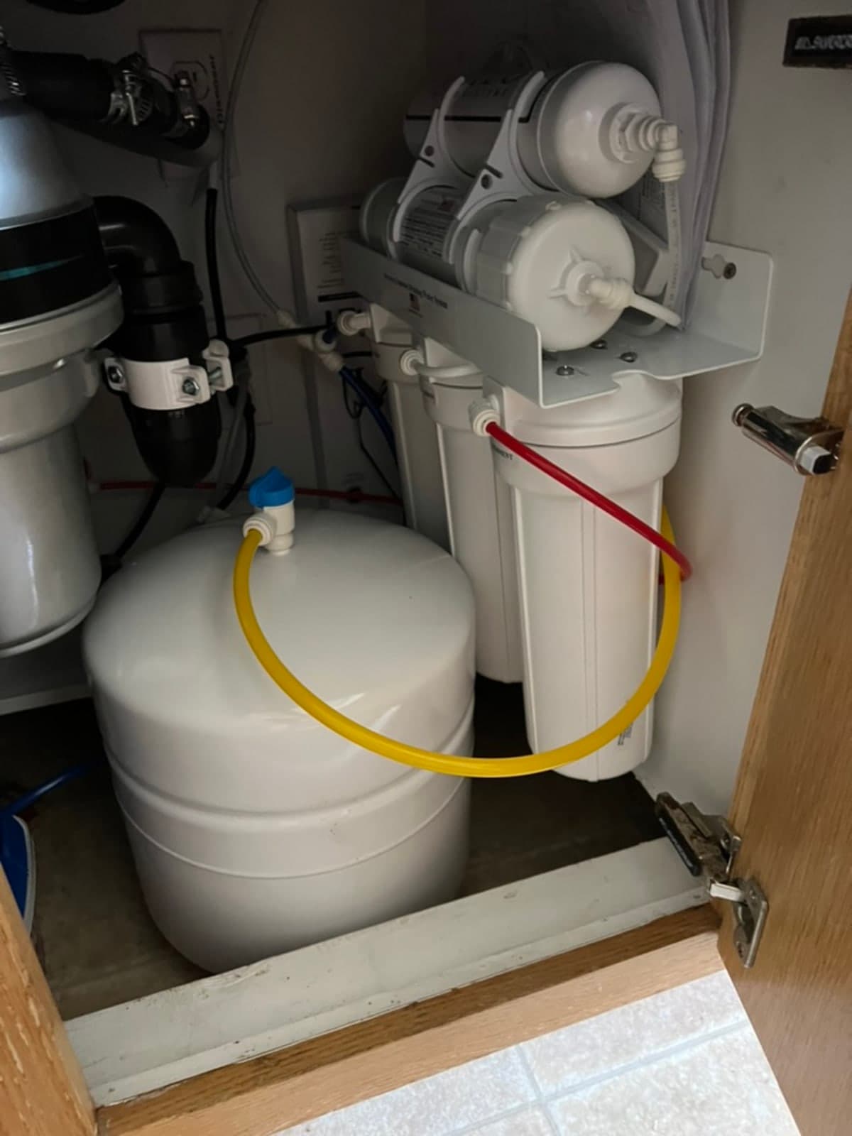 Under-sink reverse osmosis filtration system installed in Carlsbad kitchen cabinet