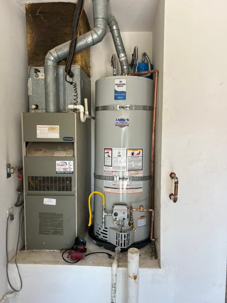 A Bradford White water heater installed beside a furnace in a North County San Diego garage