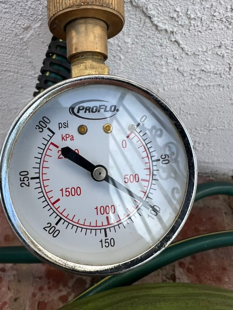 Pressure gauge reading roughly 200 psi on a Carlsbad home's water line, far above the 80 psi code maximum